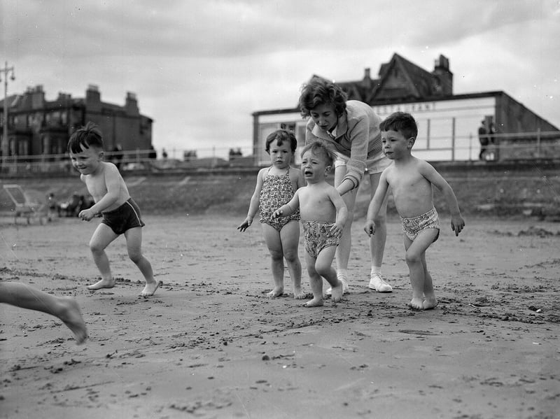 A mum persuades her little boy to go into the sea at Portobello beach, Edinburgh, during the Glasgow Fair holiday in July 1961