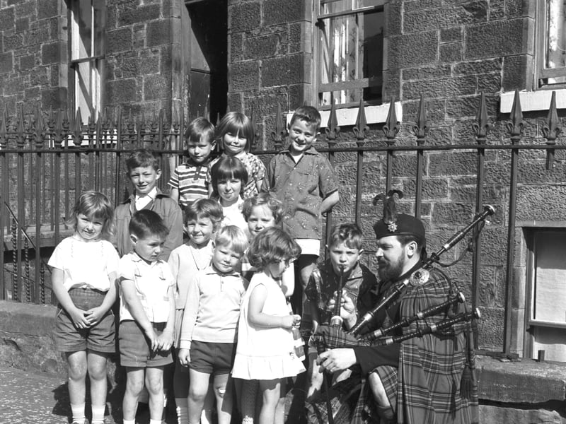Little William Cafferty helps piper John O'Connor tune up at the Burntisland Games in July 1966