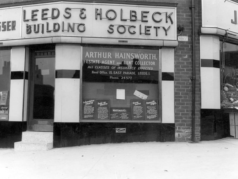 The branch of Leeds and Holbeck Building Society, on Lower Wortley Road. Also the office of Arthur Hainsworth, estate agent and rent collector. To the left is Harry Buckle gents hairdresser, on the right is no 124 John Watson greengrocer. Pictured in August 1936.