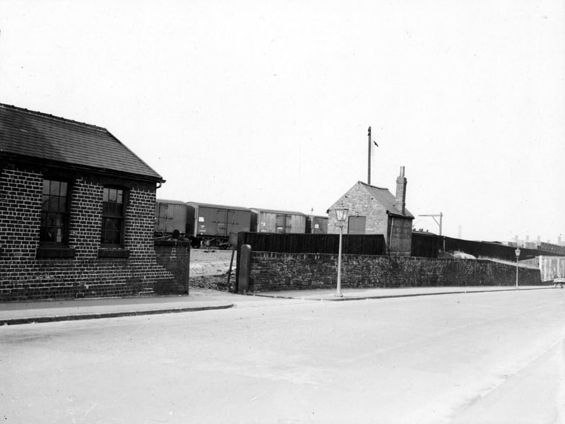 A view of Whitehall Road with goods waggons on the railway sidings at Copley Hill in the background. The photograph is titled 'Proposed site for hoarding'. A hoarding is a structure to support advertising posters. Pictured in October 1938.