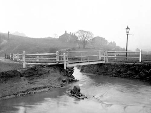Footbridge over Wortley Beck showing flood damage in the Primrose Hill area. View looking towards Leeds with the Ring Road to the right. The hoses in view are on Primrose Hill. Pictured in January 1939.