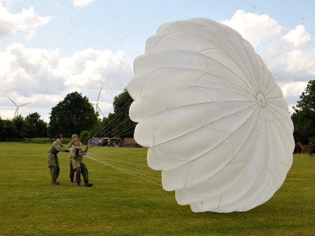 Eric Ward of Axis Allies a German paratroup re-enactment group demonstrating how to deal with a parachute after landing.