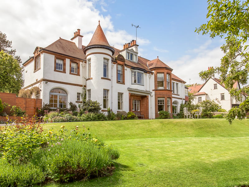 This main-door lower villa within an Arts and Crafts building in North Berwick  is accompanied by generous private gardens and a private driveway. The property is approached via a sweeping drive leading to the front door.  The front garden is beautifully maintained with a large, well-kept lawn and an abundance of established trees and shrubs.