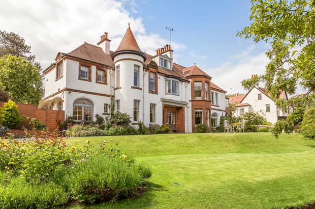 This main-door lower villa within an Arts and Crafts building in North Berwick is accompanied by generous private gardens and a private driveway. The property is approached via a sweeping drive leading to the front door. The front garden is beautifully maintained with a large, well-kept lawn and an abundance of established trees and shrubs.