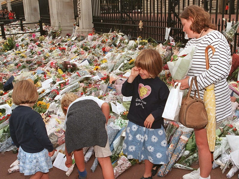 Few events have united a nation in grief like the tragic death of Diana, Princess of Wales, in a car crash in Paris on August 31, 1997. Mourners left a sea of flowers outside Buckingham Palace in tribute to the 'People's Princess', and a new version of Elton John's Candle in the Wind, known as Goodbye England's Rose, soared to the top of the charts, raising millions for charities Diana had supported. The emotion proved too much for this youngster, pictured paying her respects at the palace with her family.