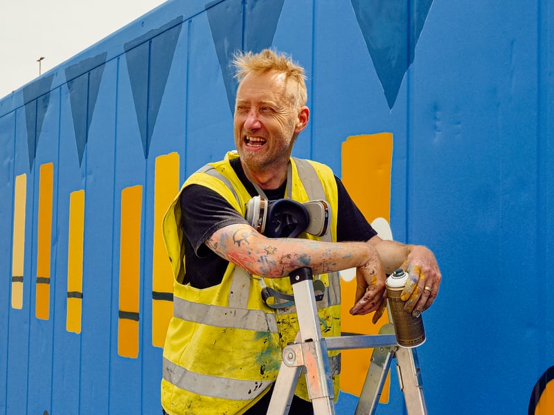 My Dog Sighs, a famous artist in Portsmouth, has teamed up with Victorious Festival to create a huge piece of artwork on a shipping container. 

Pictured: My Dog Sighs with his art