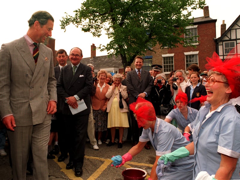 HRH Prince Charles shares a joke with some drama students from the College of Ripon and York St John who were dressed as Mrs Mopps cleaning the market place in June 1997.