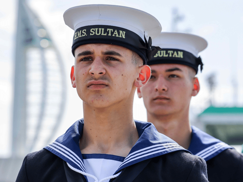 Personnel from HMS Sultan and representatives from Gosport Borough Council stand at attention as the Armed Forces Flag is raised to commence Armed Forces Week 2025.