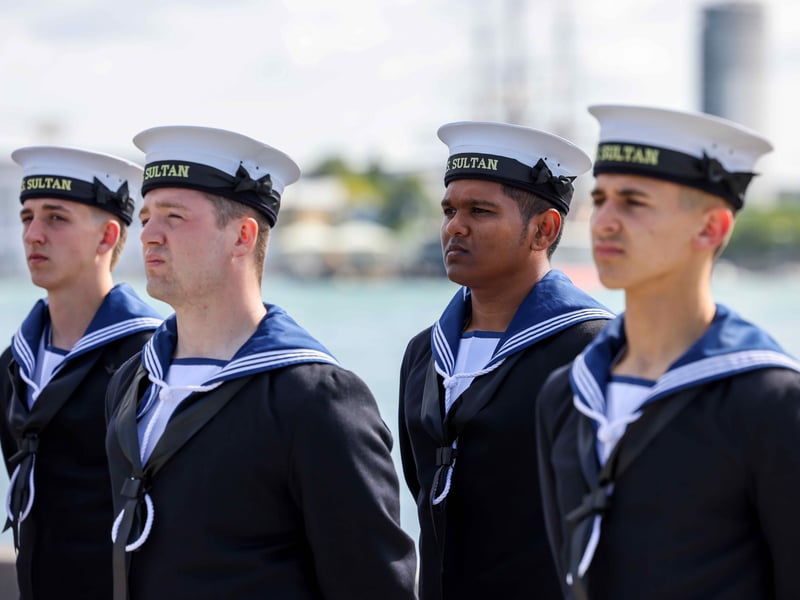 Personnel from HMS Sultan and representatives from Gosport Borough Council stand at attention as the Armed Forces Flag is raised to commence Armed Forces Week 2025.