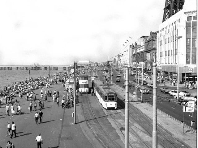 Trams on the prom surrounded by holidaymakers