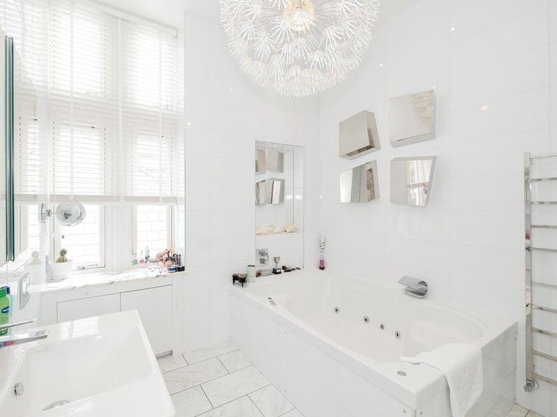 The en-suite bathroom features a large bath and modern decor.