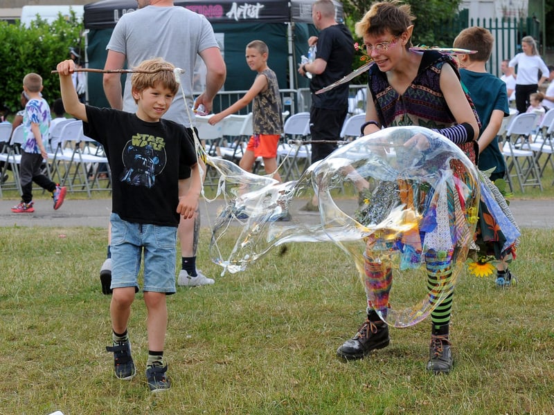 Titus Fleming, seven, of Beeston helps Kit Pixie of Yorkshire Circus make bubbles