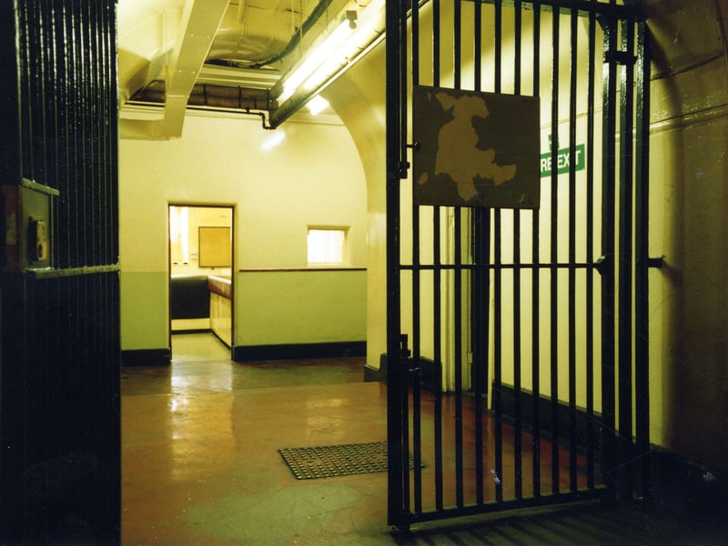 A view from gates in the Leeds Bridewell in the Town Hall, looking straight ahead to the desk in the Custody Officer's Room where prisoners would be taken on arrival. Inside the doorway, left, there is access to a passage leading to the 1864 Police entrance between two Keyworth Lions on the West side of the Town Hall frontage on The Headrow.