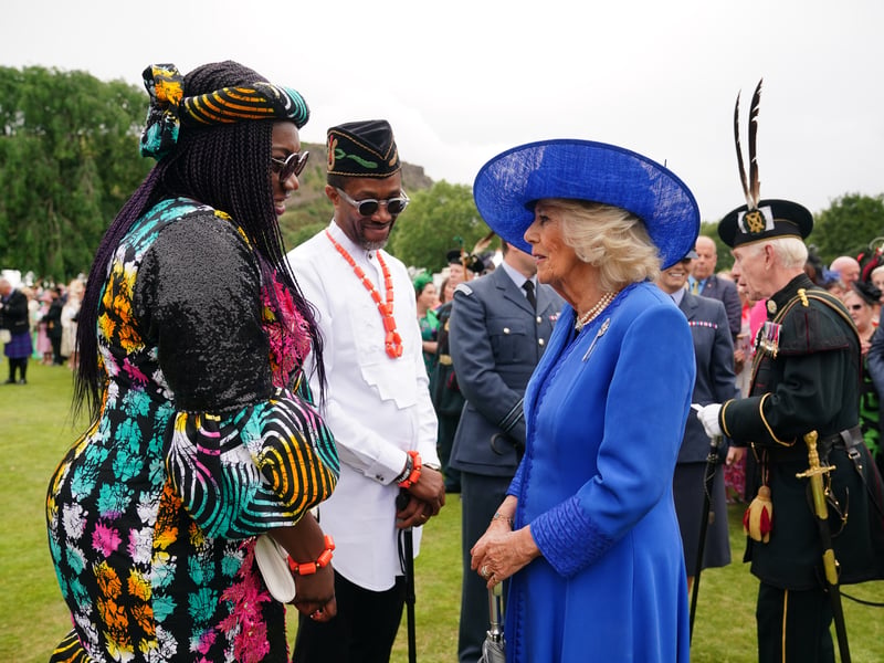 Queen Camilla speaks with Edinburgh Rotary Club members, Christie Etukudar and her husband Idara, during the Sovereign's Garden Party at the Palace of Holyroodhouse in Edinburgh. 