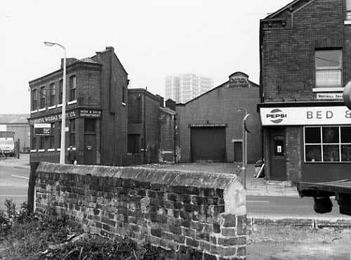 To the left of this view from September 1971 is the junction of Copley Hill and Whitehall Road where the Leeds Co-operative Wholesale society Hide and Skin department is located. This was an 'L' shaped building with a garage door seen at the end of Eveline View in the centre of the photo. A datestone reads 1919. A bed and breakfast at number 128 Whitehall Road follows to the right.