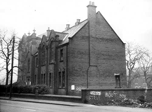 December 1972 and in focus is a side view of a large building with broken windows once the premises of the Boy's Brigade (27th Leeds Company) at the junction of Upper Wortley Road and Churchill Street.