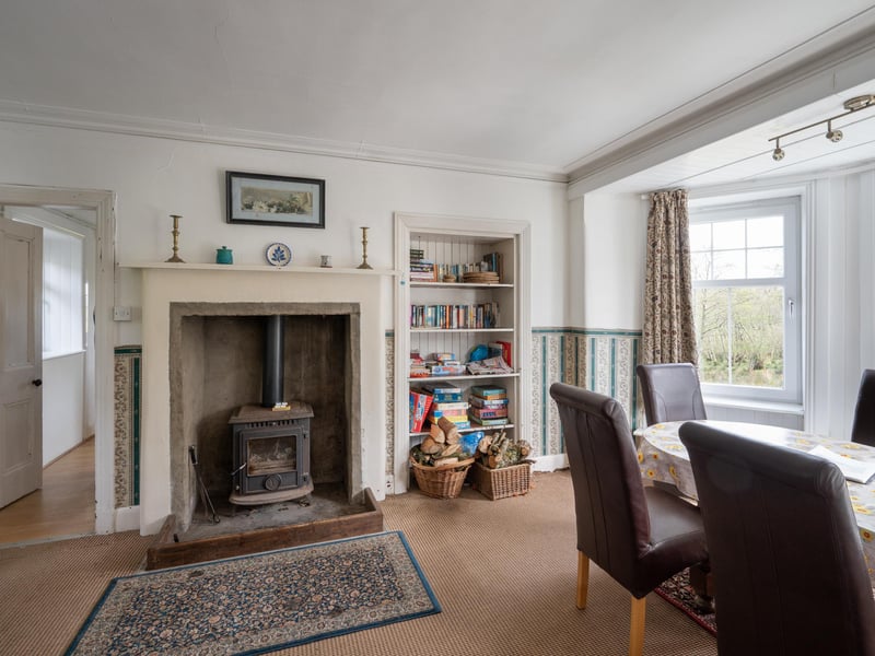 The well-sized living room features a wood-burning stove and bay window.