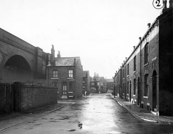 A view along Croydon Place with Domestic Street Bridge, Staincross Place and Staincross Street on the left. A tobacconists can be seen in the background. A woman and a streetlamp are visible. Pictured in November 1949.