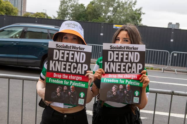 Two fans hold "Defend Kneecap" posters outside their gig at Glasgow's O2 Academy.