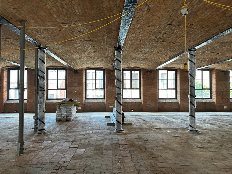 A peak inside the once run-down structure reveals spacious floors with high, rounded ceilings and stripped-back brickwork.