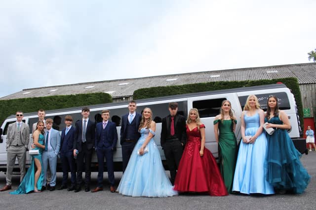 A large group in front of their limo