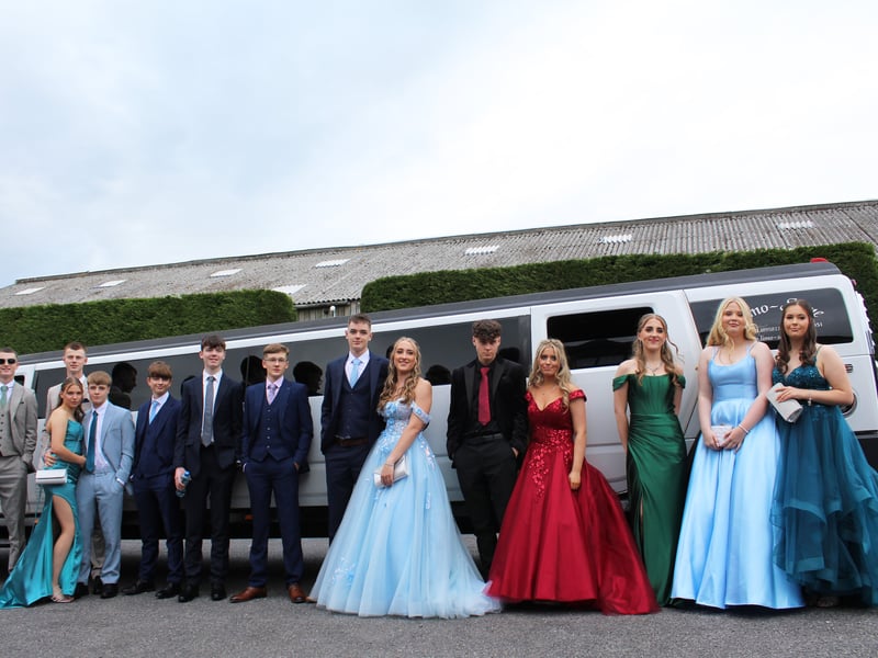 A large group in front of their limo