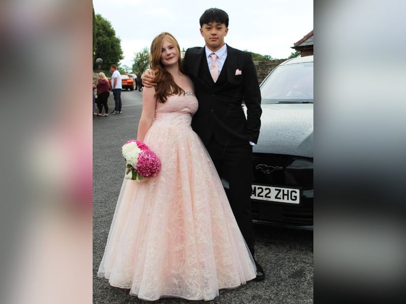 A prom couple pose for a picture