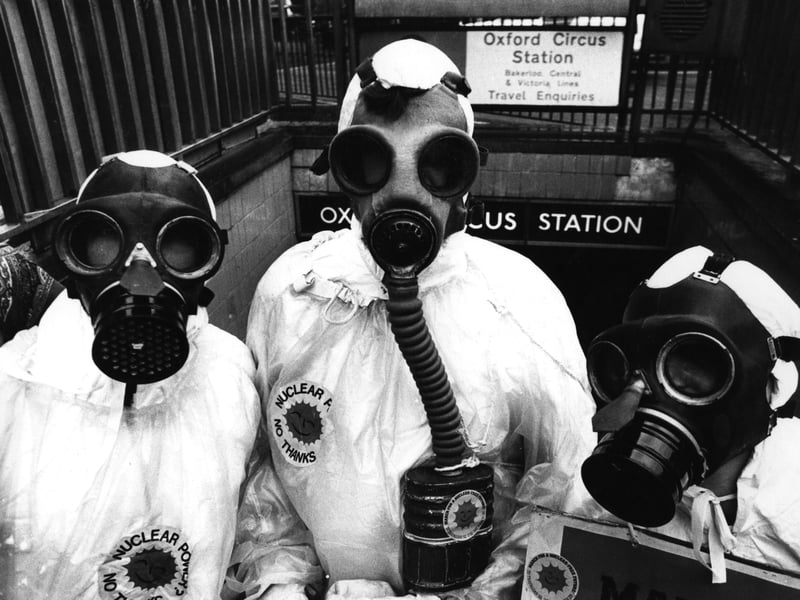 Members of the environmental pressure group Friends Of The Earth, dressed in gas masks and protective clothing, hand out anti-nuclear material at an entrance to Oxford Circus underground station, London, in July 1980