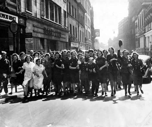 An excited group of merry-makers celebrate VJ Day on Albion Street.