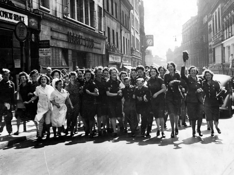 An excited group of merry-makers celebrate VJ Day on Albion Street.