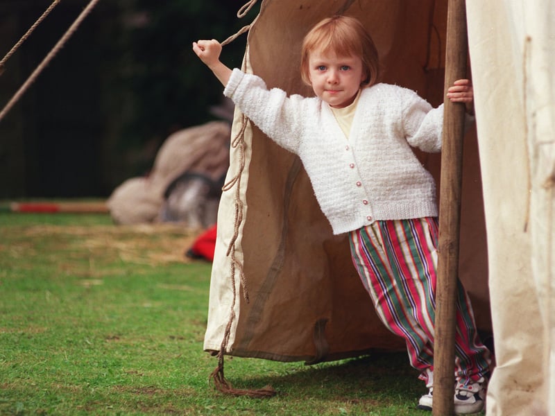 A visiting youngster peeps out of one of the tents to see what's happening at Bishops' House, Meersbrook Park, Sheffield, as part of the mini battle held there over the weekend in 1999