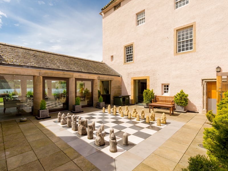 Linked to the glass panelled dining/living room, the inner courtyard includes the large chess board.