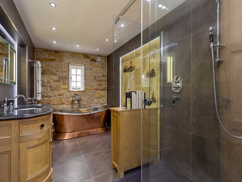Just off from the main bedroom is a large bathroom with copper bath and double shower. 

