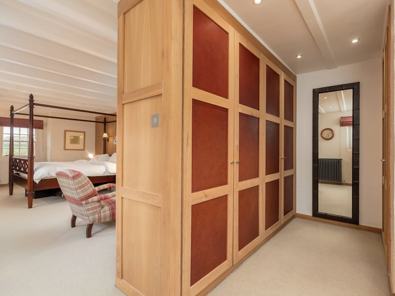 The large principal bedroom suite includes oak panelled wardrobe doors and a dressing area.