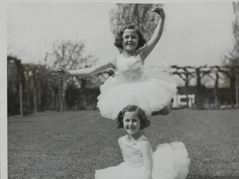 Nancy Munks, eight, who won the 1934 All-England Dancing Championship, with her twin sister, Mollie, who won the championship the previous year, aged seven. The talented duo are pictured here at their home in Northampton.