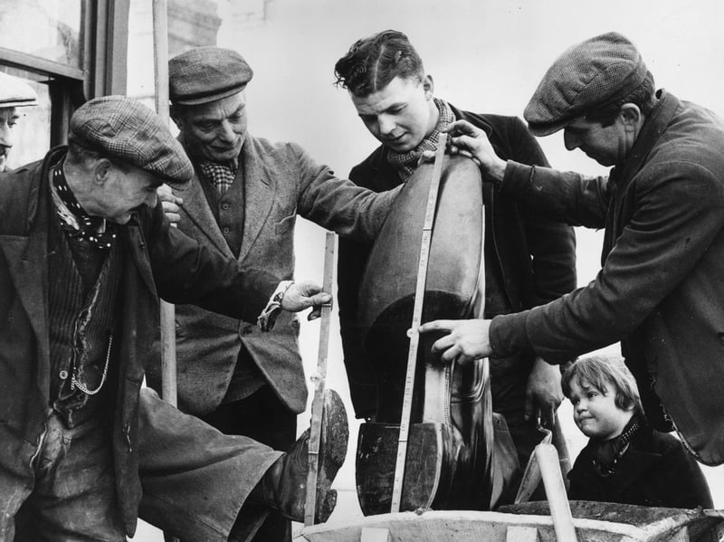 Roadmen inspect a giant boot made especially made for Northampton Town FC, in March 1937