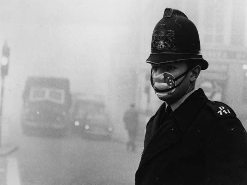 A police officer wearing a mask for protection against the thick fog which hit most of the country and turned to smog in the city