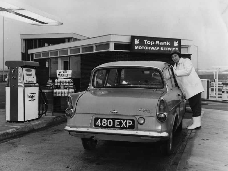 A motorist cleans her windscreen at a service area on the M6 motorway