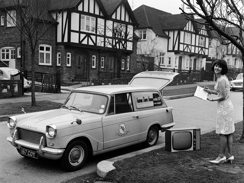 An employee from a TV rental shop delivers a television to a customer in 1961