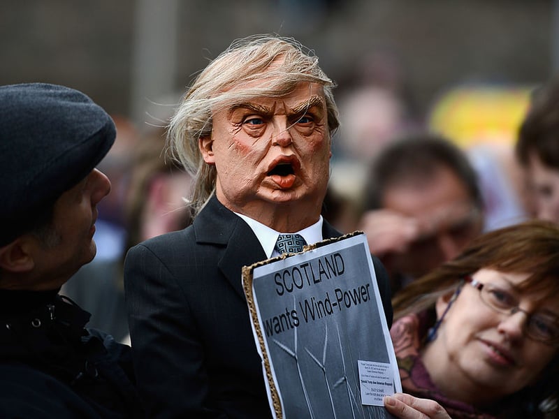 A wind power campaigner greeted Donald Trump outside the Scottish Parliament.