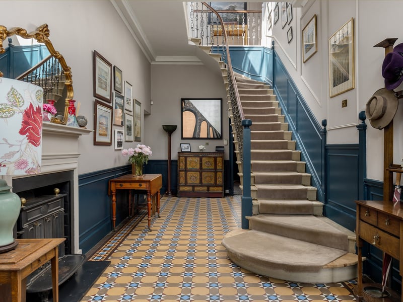 The reception hall features a grand cantilevered staircase and a wood burning stove.
