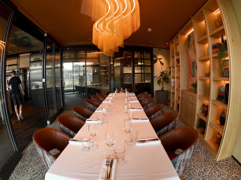The venue features a sleek glass-walled private dining room.