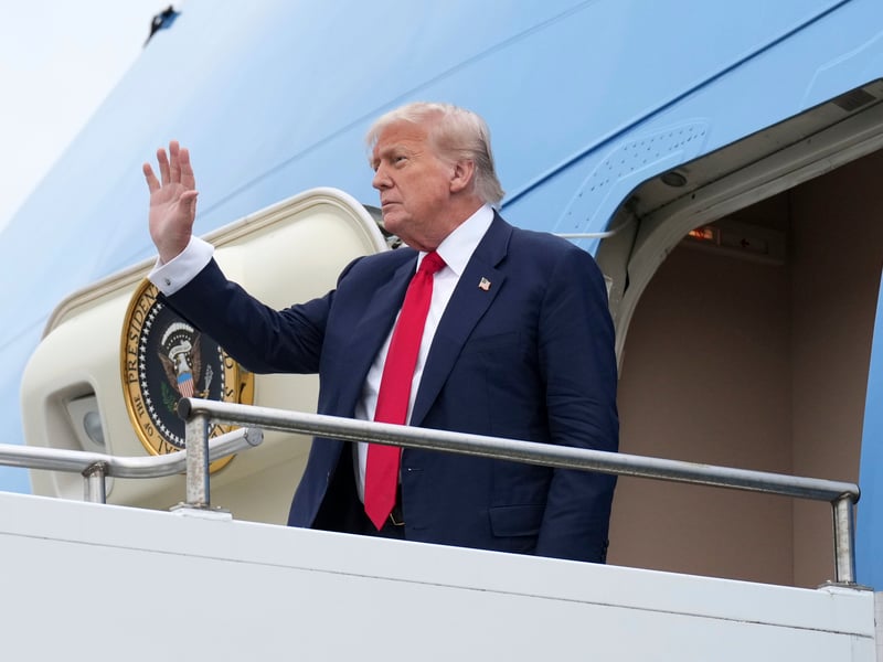 President Donald Trump waves as he disembarks from Air Force One
