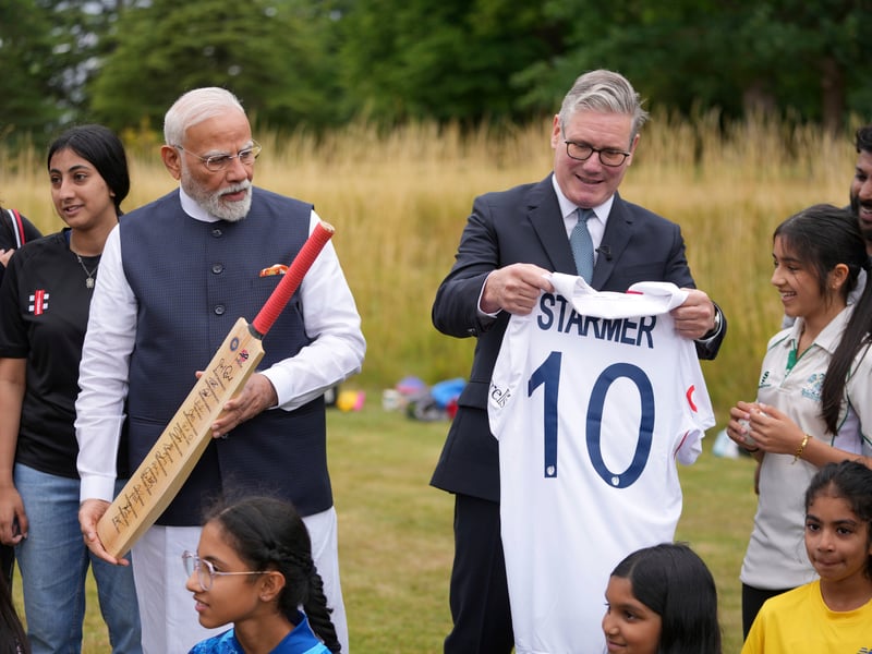 Prime Minister Sir Keir Starmer (centre right) with the Prime Minister of India, Narendra Modi (centre left), hold a Cricket bat, signed by Indian Cricket players, and a shirt as they meet school children during his visit to Chequers, the country house of the serving Prime Minister of the UK, near Aylesbury in Buckinghamshire