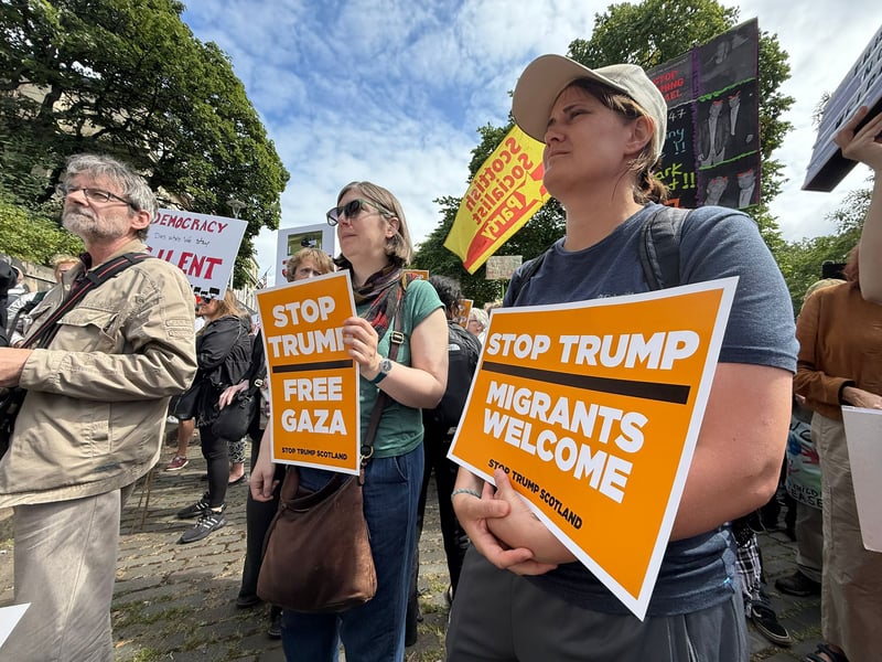 "Stop Trump" and "Migrants Welcome"