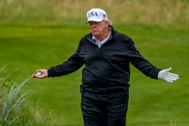 U.S. President Donald Trump reacts as he plays a round of golf at Trump Turnberry golf course.