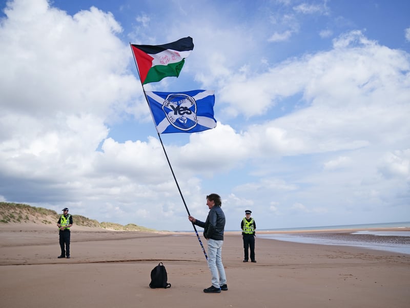 A protester on Balmedie Beach ahead of a visit by the US President Donald Trump and Prime Minister Sir Keir Starmer at the president's Menie golf course in Aberdeenshire. 
