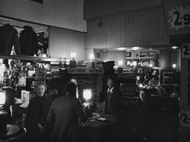 Shoppers browse the goods in semi-darkness, lit only by Camping Gaz lamps, during a power cut at a shop in December 1973. Nearly all businesses, with food shops being an exception, had their electricity use cut to three days a week after coal production halved as a result of industrial action by the National Union of Mineworkers.