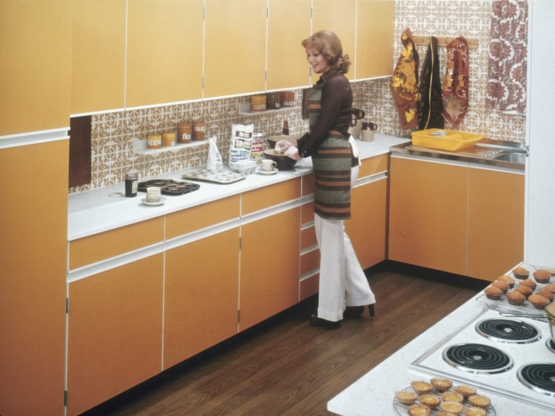 A woman baking cakes in a typical 70s fitted kitchen in around 1975