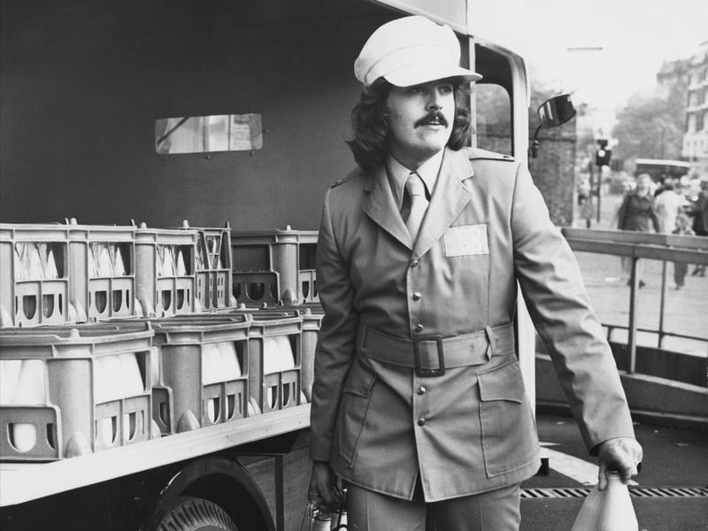 A milkman wearing a new prize-winning uniform, designed to make him more attractive to British housewives, delivers bottles in around 1972